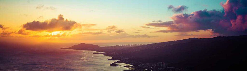 Sunset over Oahu with Waikiki Beach and Diamond Head in the distance, from the summit of Koko Head Crater.