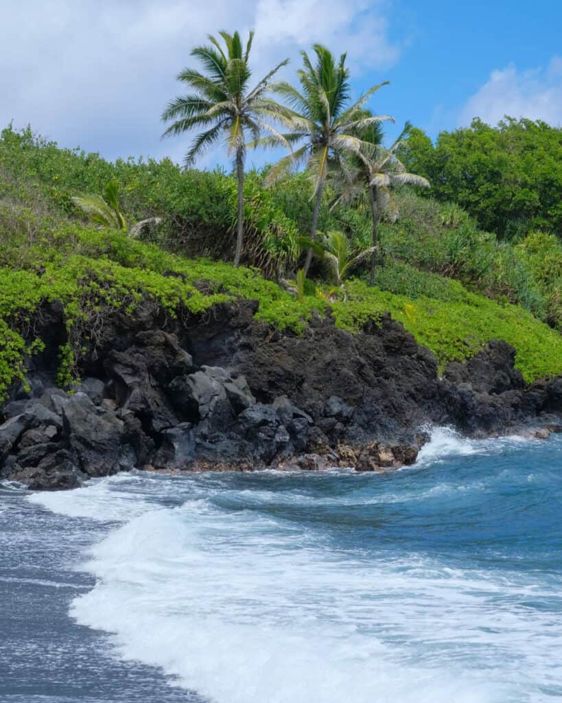 Black sand beach in Maui, HI, on a sunny day