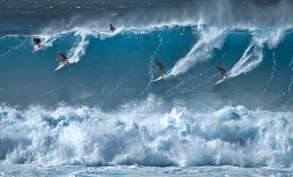 Surfers riding a wave at Waimea Bay on the North Shore of Oahu in Hawaii