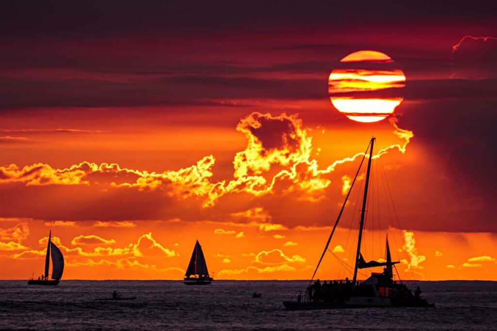 Watching a stunning sunset from a cruise, one of the most romantic things to do in Waikiki!