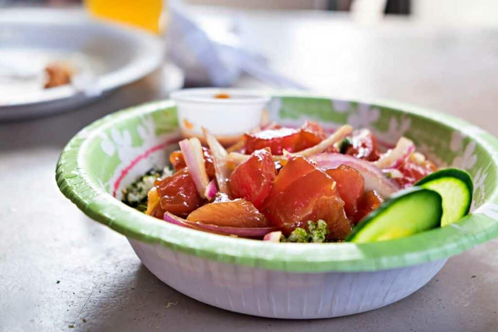 Sampling raw fish Hawaiian poke bowl on a Waikiki food tour, one of my favorite fun things to do in Waikiki, HI