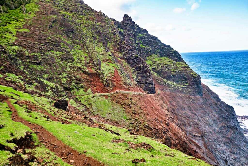 Crawler's Ledge, a section of the Kalalua Trail that hugs the mountainous cliffside with steep falls to the rocky ocean below