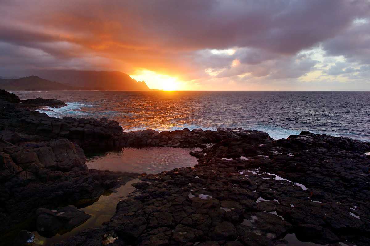 Sunset over the Na Pali Cliffs from Queen's Bath Trail, one of the best easy Kauai North Shore hikes near Princeville