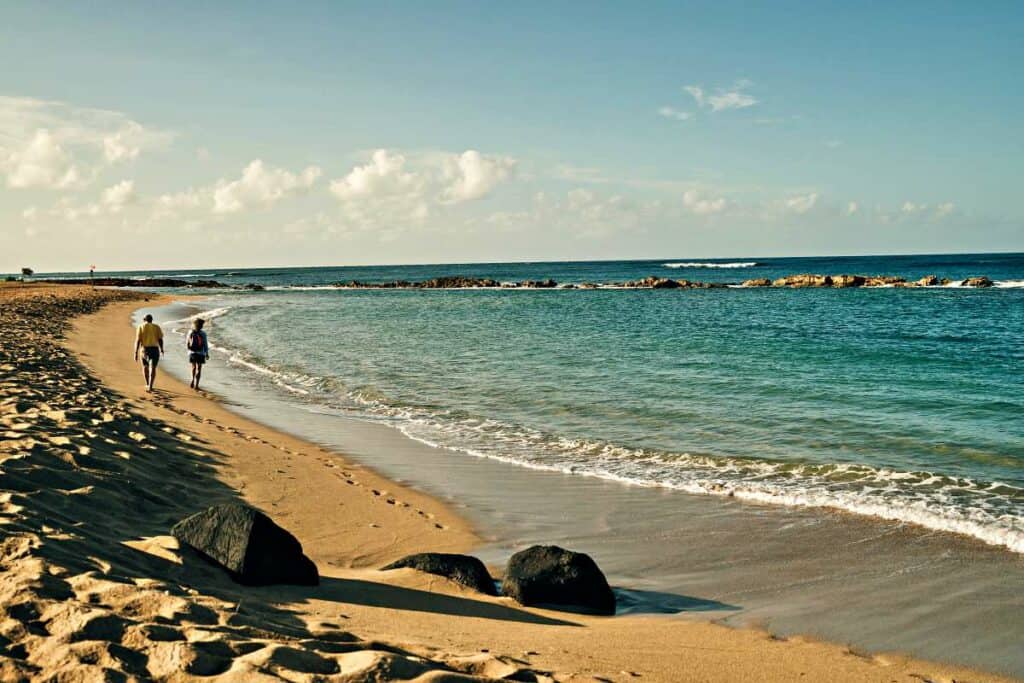 Taking a leisurely stroll on a mostly deserted Salt Pond Beach, Kauai, Hawaii
