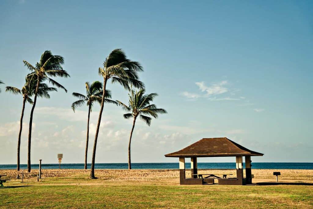 Covered pavilions and palm trees providing shade on Salt Pond Beach Park, Kauai, Hawaii