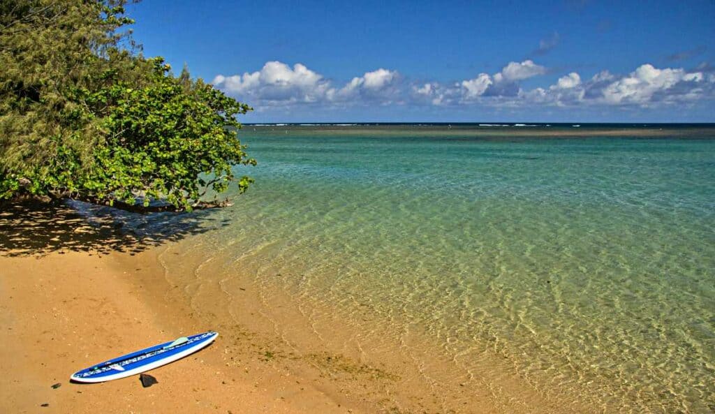 Standup paddle board on  Anini Beach, next to placid waters