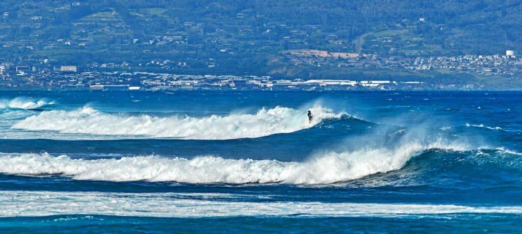 Professional surfers riding towering waves at Ho'okipa Beach Park, Maui, HI