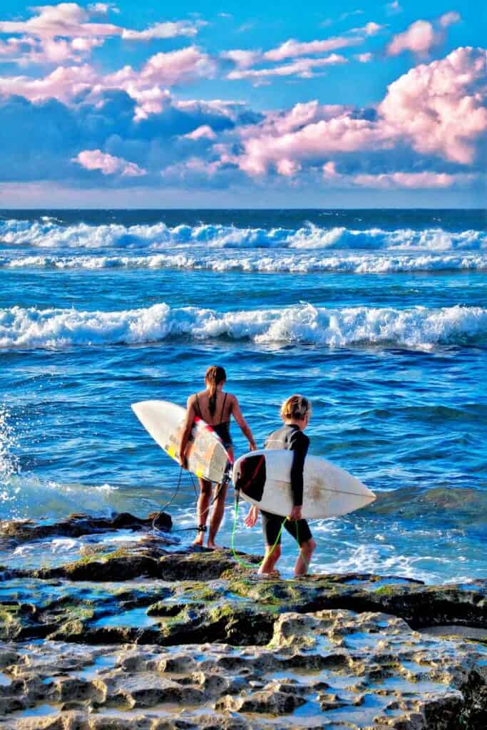 Young surfers entering the waters at Ho'okipa Beach, Maui, HI