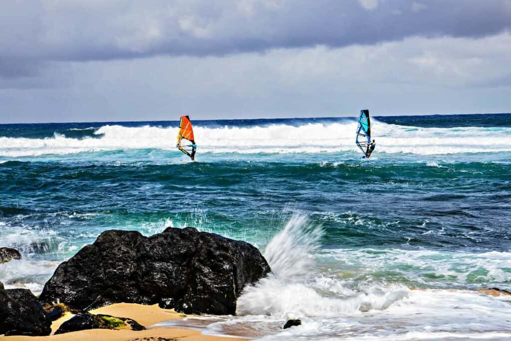 Experienced windsurfers heading to meet the waves at Ho'okipa Beach Park, Maui, HI