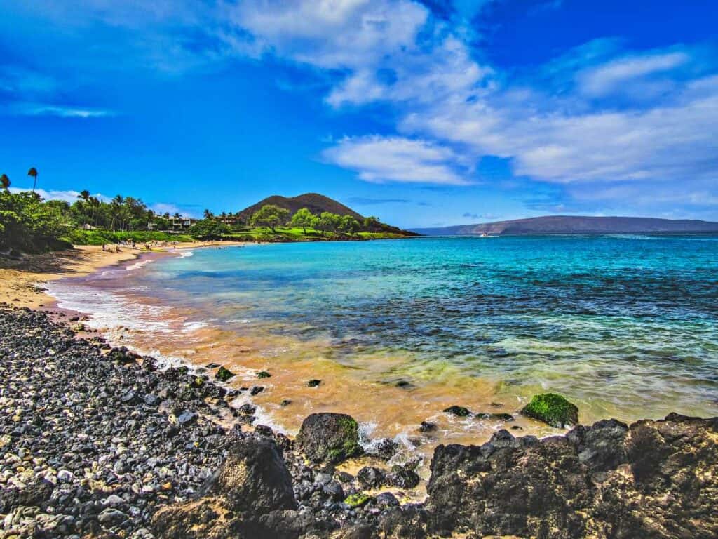 Beautiful Maluaka Beach, Maui, HI, with a long strip of golden sands and lava rocks at  each end