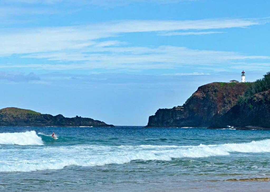 Surfer riding the waves at Secret Beach, Kauai, HI