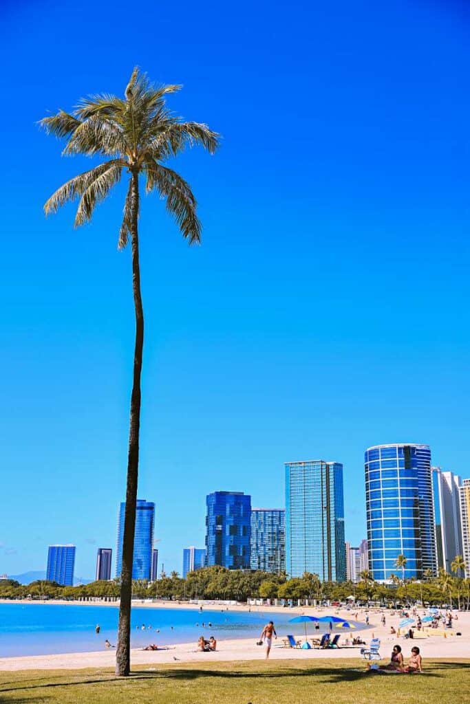 Stunning blue waters, golden sands, and tall, swaying palm trees at Ala Moana Beach Park, Oahu, HI