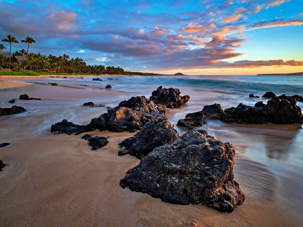 Keawakapu Beach on Maui at sunset with lava rocks in the foreground