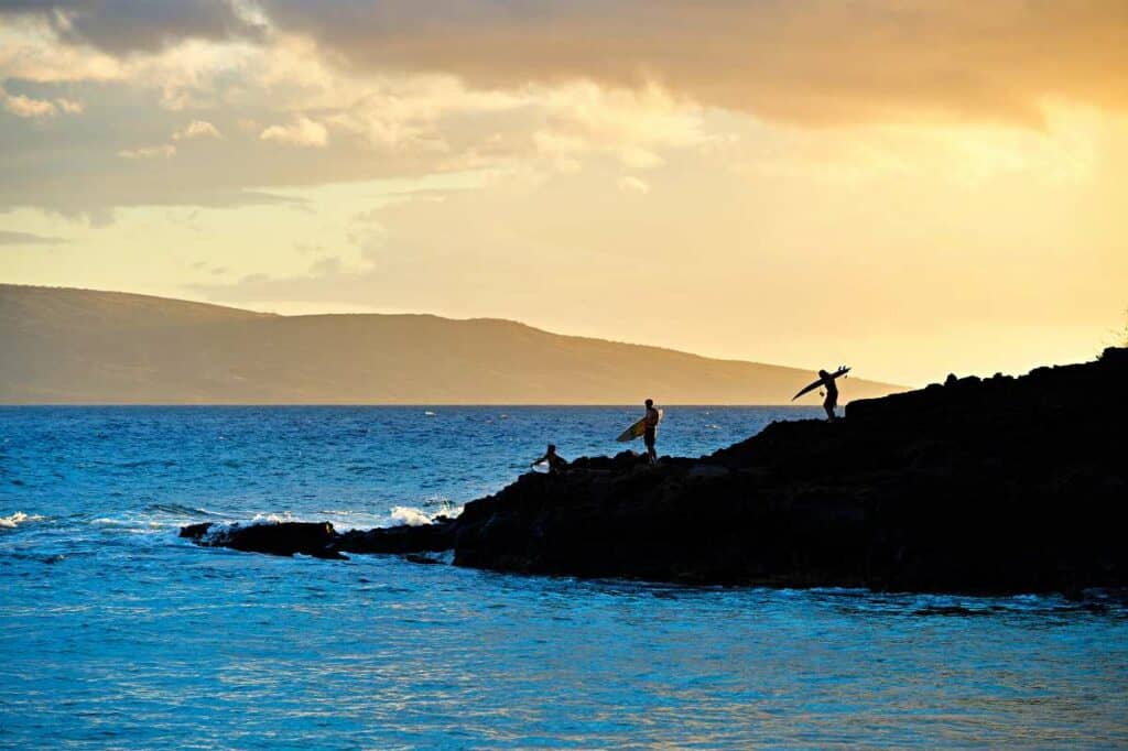 Surfers preparing to jump in the water in Makena Beach, Maui, Hawaii.