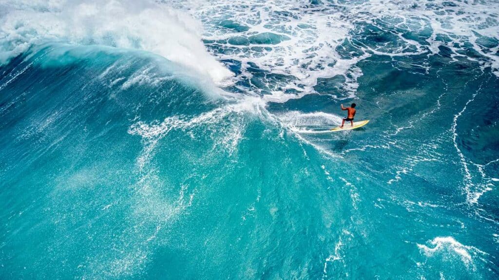 Professional surfer riding massive winter waves at Sunset Beach, Oahu, Hawaii