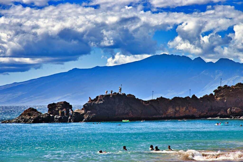 Tourists swimming and cliff jumping at Ka'anapali Beach, Maui, HI