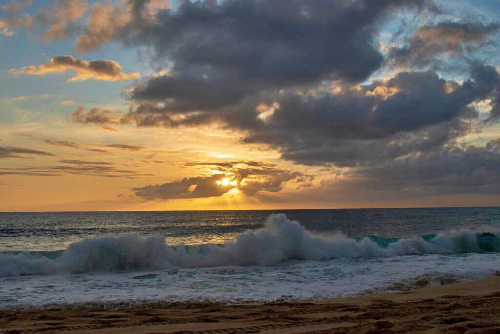 Colorful sunset at Laniakea Beach, in the midst of gathering storm clouds