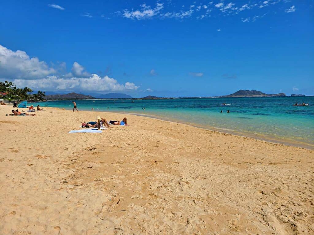 Sunbathers on the fine, golden sands of Lanikai Beach, Hawaii