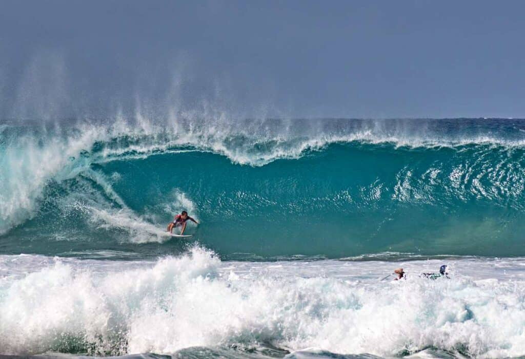 Professional surfers riding the enormous waves on Banzai Pipeline, Ehukai Beach, Hawaii