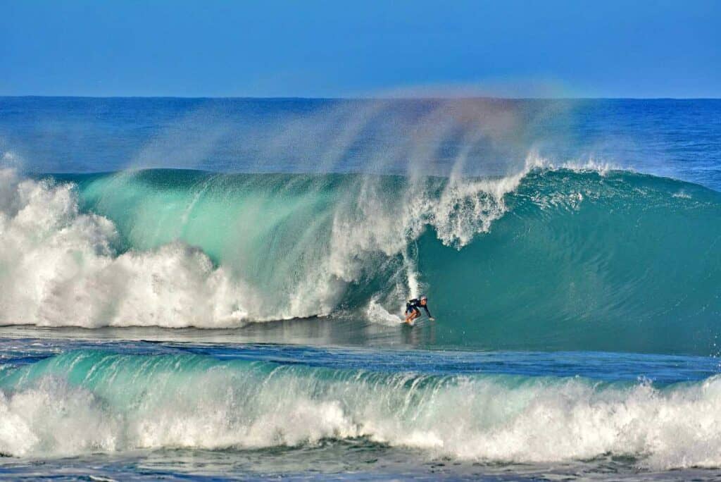 Professional surfer riding the inner wall of the barrel-shaped waves on the Banzai Pipeline of Hawaii