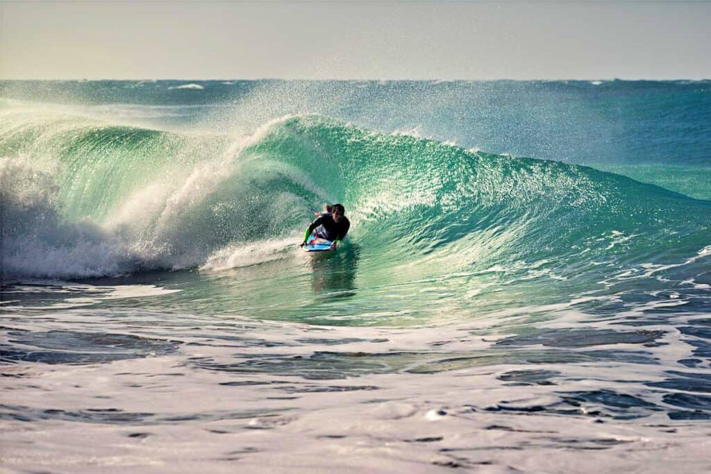 Boogie boarder riding a barrel-shaped wave at Brennecke's Beach, Kauai