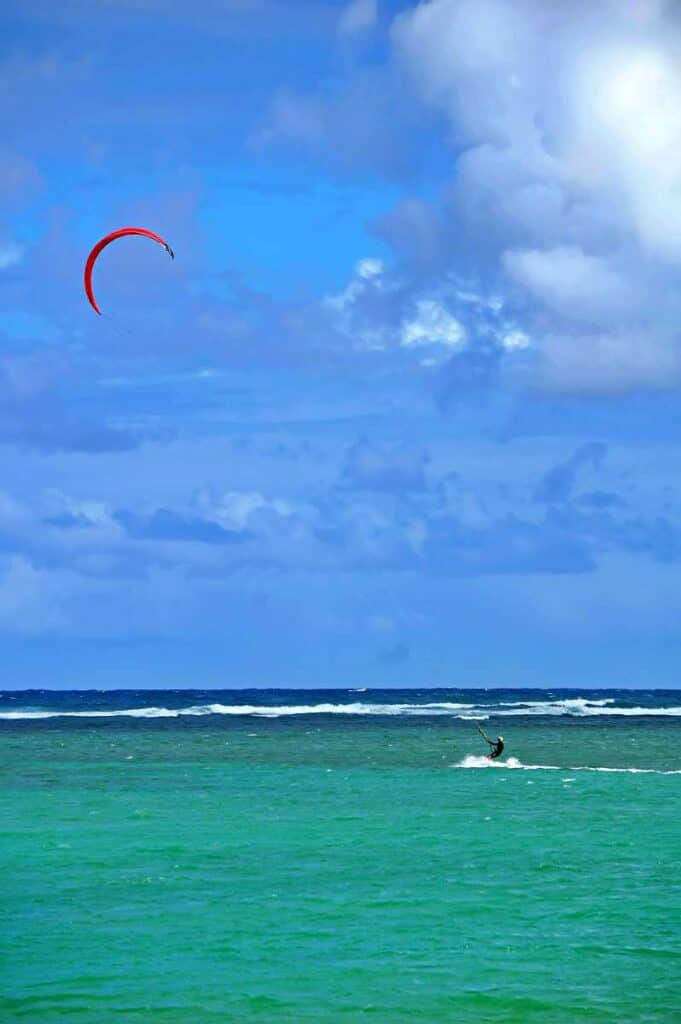 Kite surfers and kite boarders enjoy riding the windy open ocean waters at Kawailoa Bay, Mahaulepu Beach, Kauai